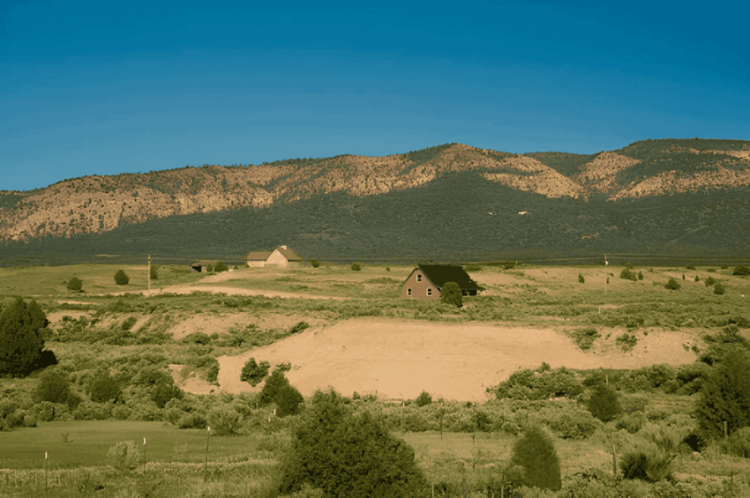 Small houses in a grassy valley landscape.